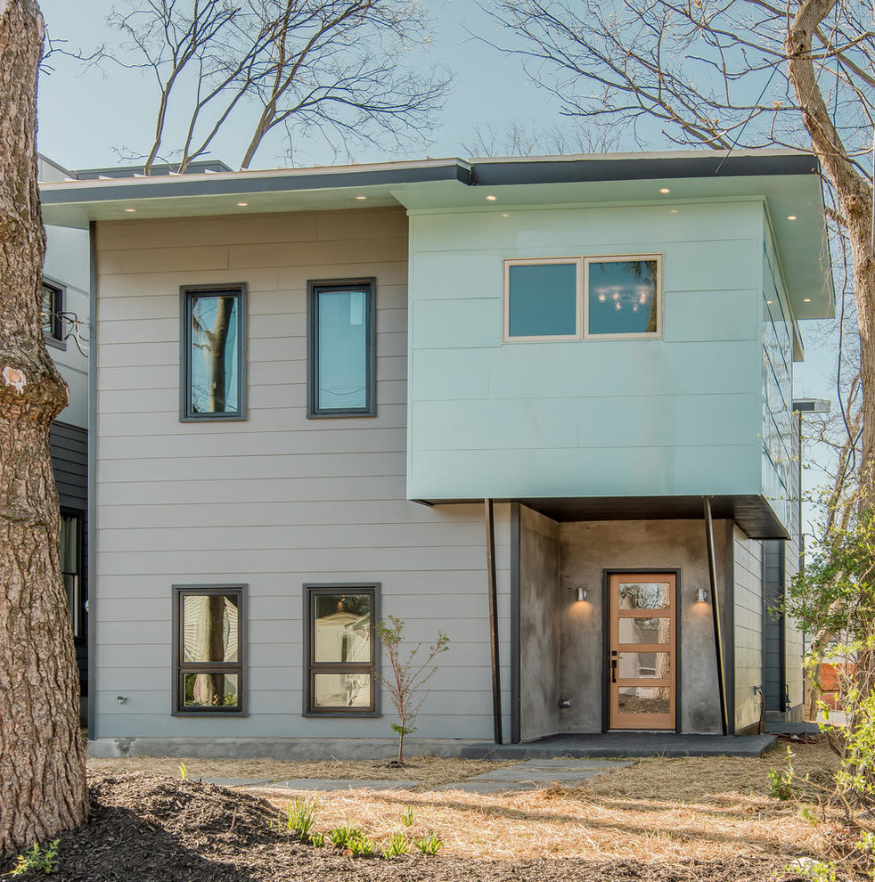 Ejemplo de fachada gris minimalista de tamaño medio de dos plantas con revestimiento de aglomerado de cemento