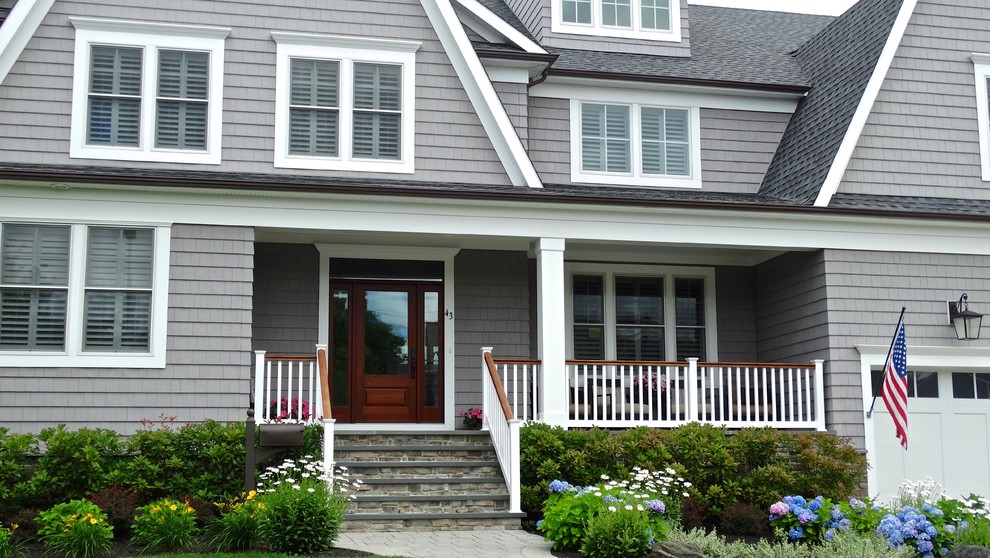 Large elegant gray two-story wood house exterior photo in New York with a clipped gable roof and a shingle roof