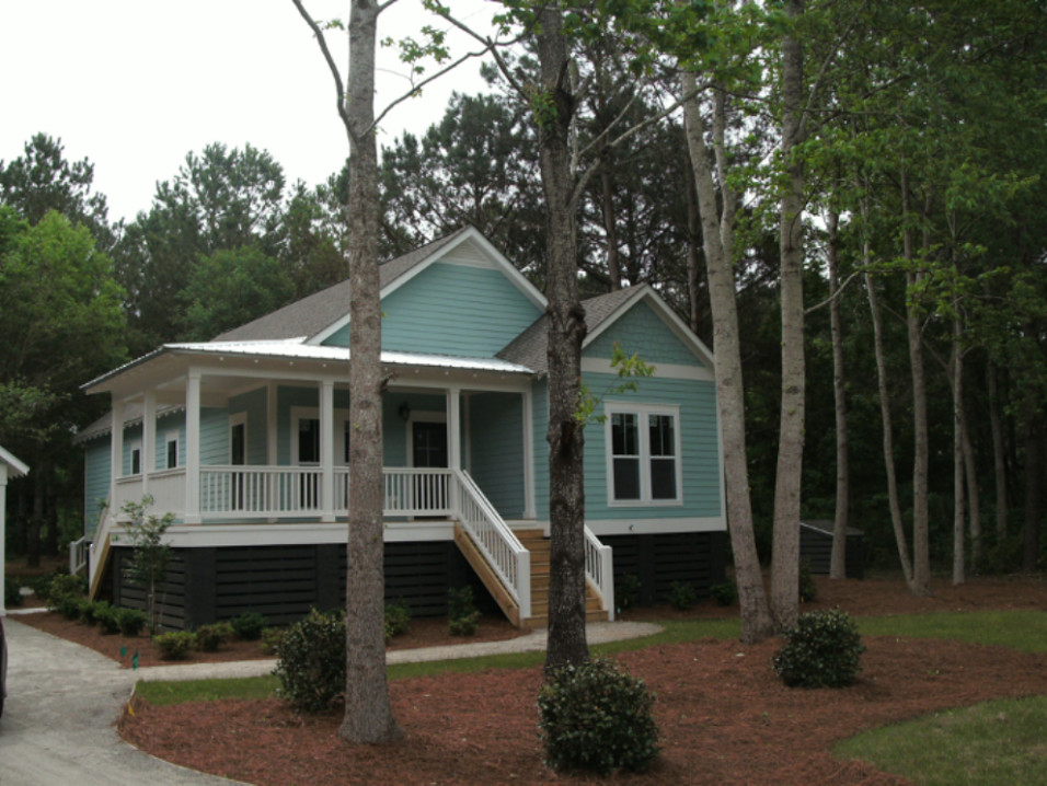 Foto della villa piccola blu country a un piano con rivestimento in legno, tetto a padiglione e copertura mista