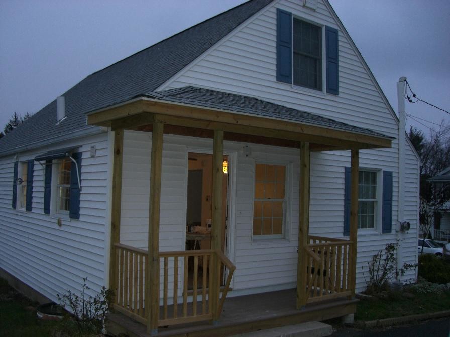 Example of a mid-sized white one-story wood exterior home design in New York with a hip roof