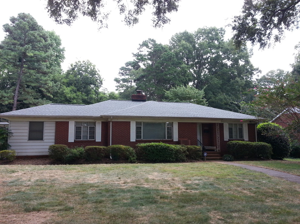 Small elegant white one-story brick house exterior photo in Charlotte with a clipped gable roof and a shingle roof