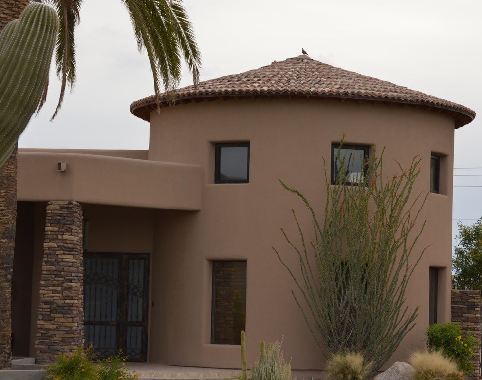 Modelo de fachada de casa beige de estilo americano con revestimiento de adobe, tejado a cuatro aguas y tejado de teja de barro
