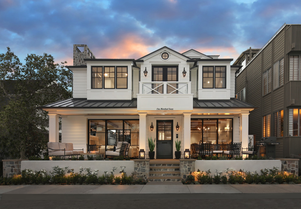 Diseño de fachada de casa blanca costera de dos plantas con tejado a dos aguas y tejado de metal