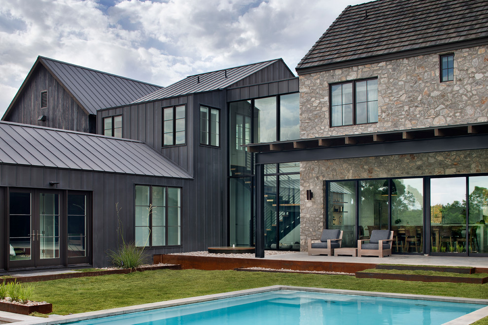 Réalisation d'une façade de maison champêtre à un étage avec un revêtement mixte, un toit à deux pans et un toit en métal.