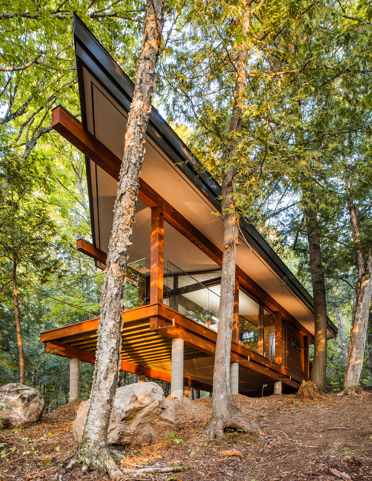 Idée de décoration pour une façade de maison design en bois de plain-pied avec un toit plat.