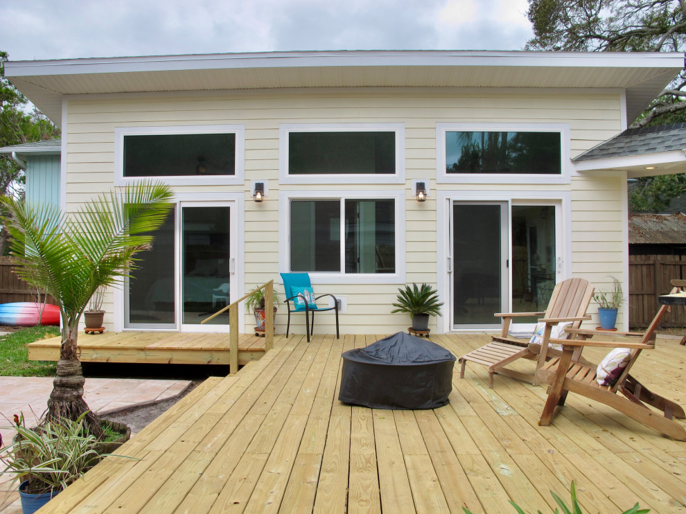 Kleines, Einstöckiges Modernes Einfamilienhaus mit Faserzement-Fassade, gelber Fassadenfarbe, Pultdach und Schindeldach in Tampa