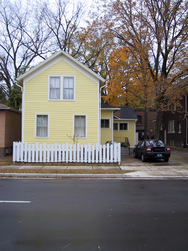 Idée de décoration pour une petite façade de maison jaune victorienne en bois à un étage.