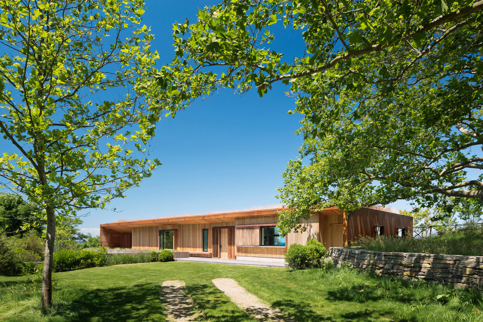 Свежая идея для дизайна: деревянный, двухэтажный, коричневый частный загородный дом в стиле модернизм с плоской крышей и зеленой крышей - отличное фото интерьера