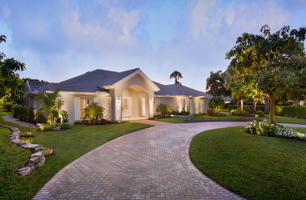 Mid-sized minimalist beige one-story stucco exterior home photo in Miami with a hip roof