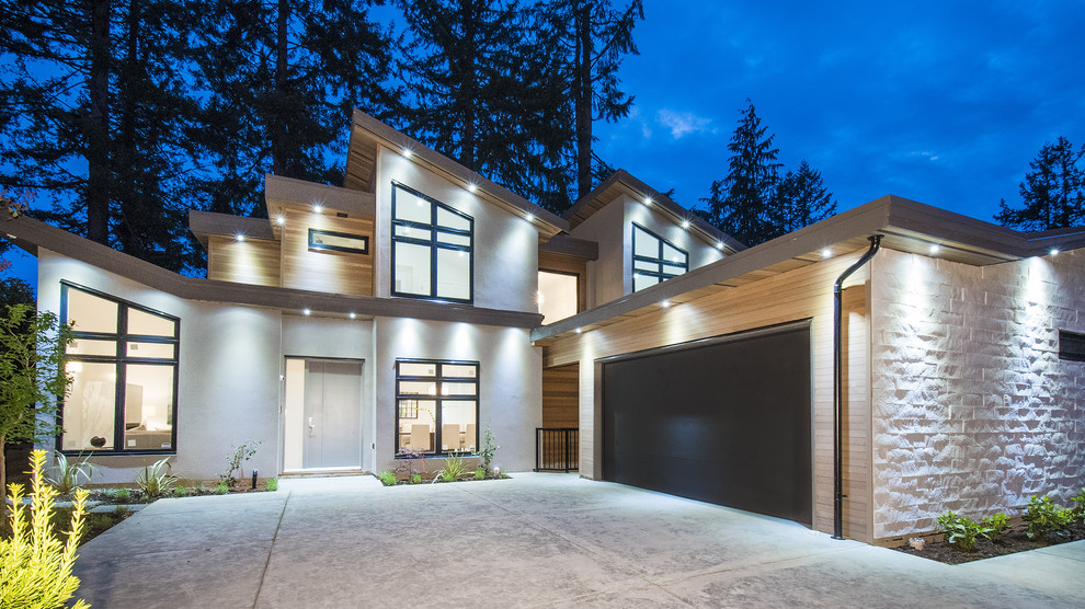 Diseño de fachada de casa beige actual de tamaño medio de tres plantas con revestimiento de estuco, tejado plano y tejado de metal