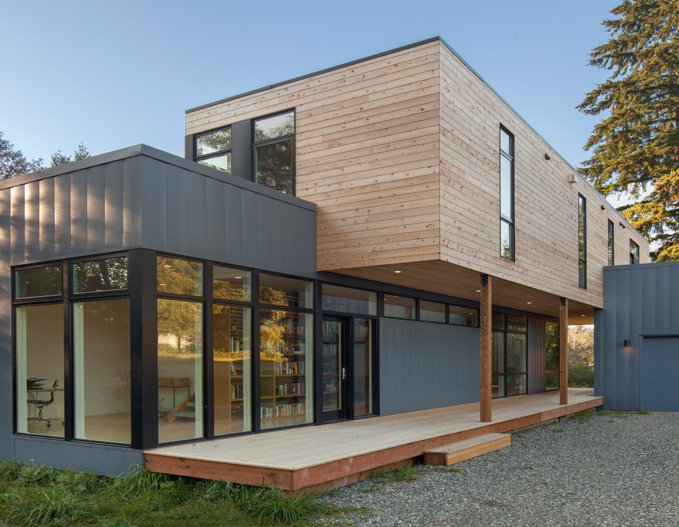 Idée de décoration pour une petite façade de maison multicolore minimaliste à un étage avec un revêtement mixte et un toit plat.