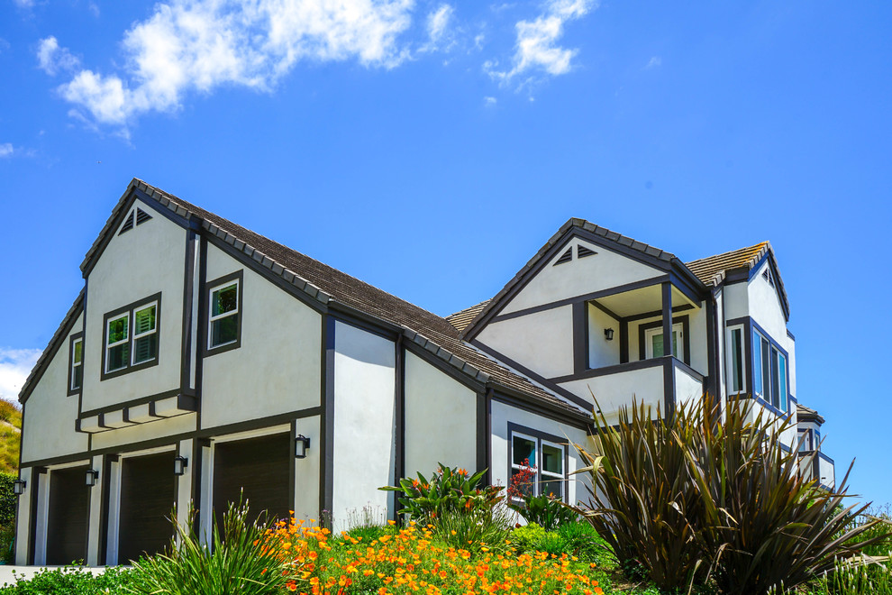 Imagen de fachada de casa beige y marrón contemporánea grande de dos plantas con revestimiento de estuco, tejado de teja de madera, tejado a cuatro aguas y panel y listón