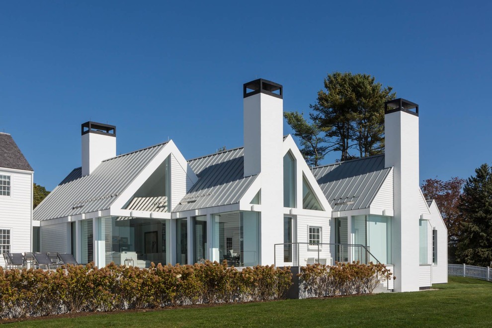 Идея дизайна: большой, двухэтажный, белый частный загородный дом в стиле модернизм с двускатной крышей и металлической крышей