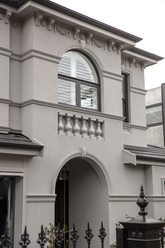 Foto de fachada de casa gris clásica de tamaño medio de dos plantas con revestimiento de ladrillo, tejado a cuatro aguas y tejado de teja de barro