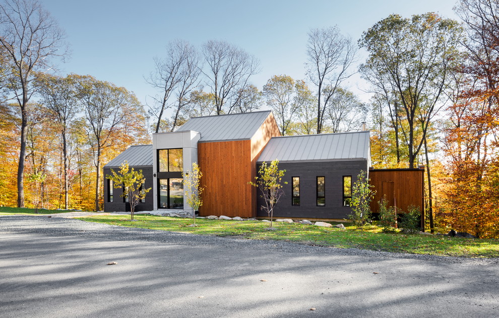 Идея дизайна: двухэтажный, серый частный загородный дом в современном стиле с комбинированной облицовкой, двускатной крышей и металлической крышей