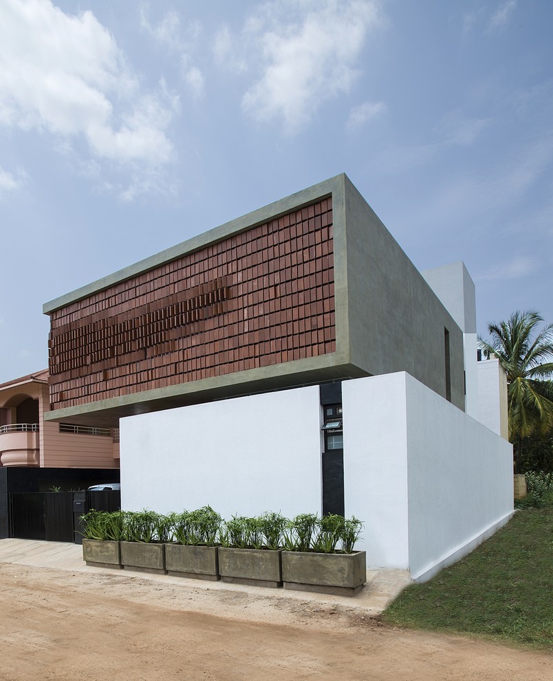 Large and multi-coloured contemporary house exterior in Bengaluru with a flat roof.