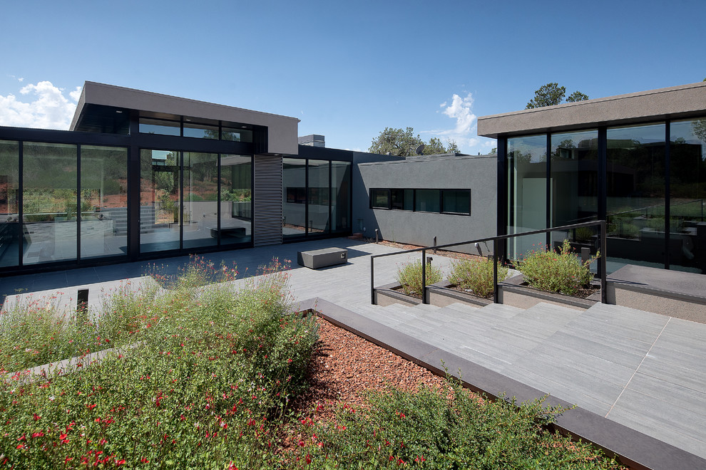 Modelo de fachada de casa beige moderna de tamaño medio de una planta con revestimiento de metal y tejado plano