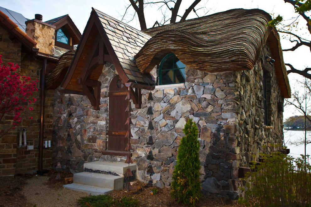 Esempio della facciata di una casa piccola eclettica con rivestimento in pietra