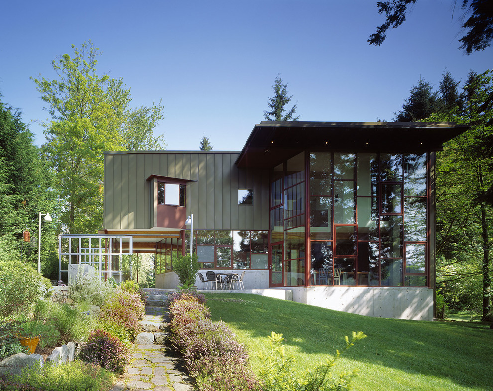 Exemple d'une façade de maison verte tendance à un étage avec un revêtement mixte et un toit plat.