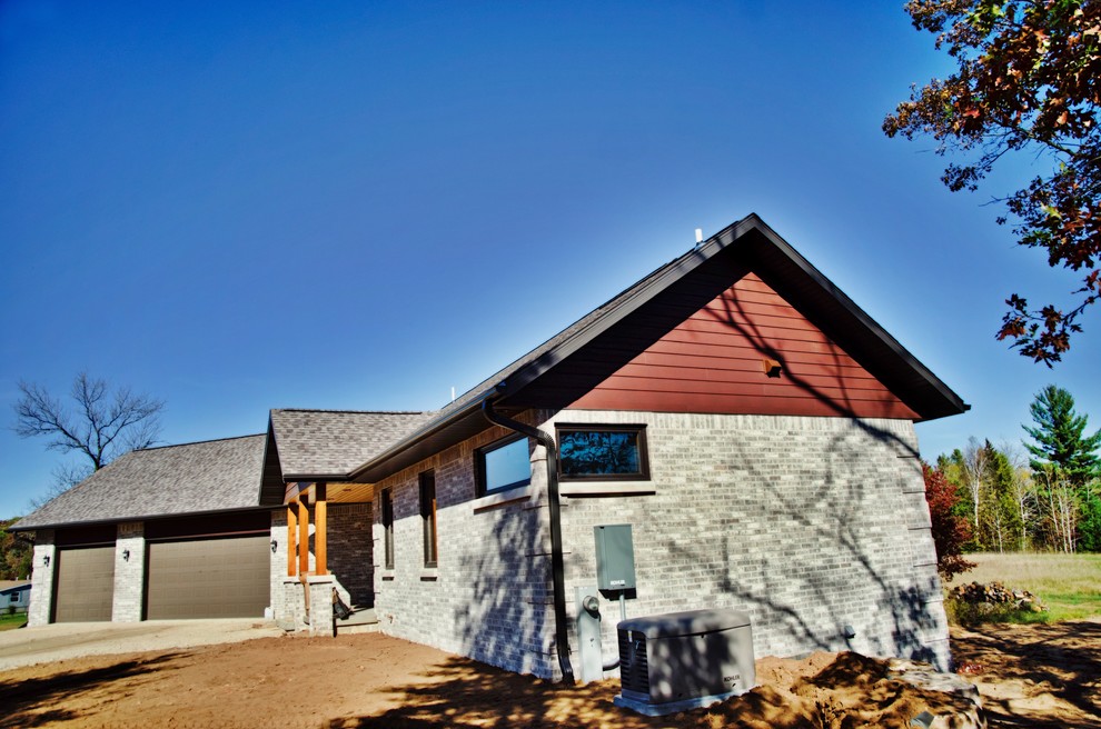 Ejemplo de fachada de casa multicolor de estilo americano grande de una planta con revestimiento de ladrillo, tejado a dos aguas y tejado de teja de madera