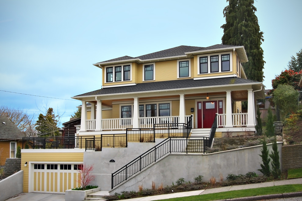Esempio della facciata di una casa american style con rivestimento in legno e scale