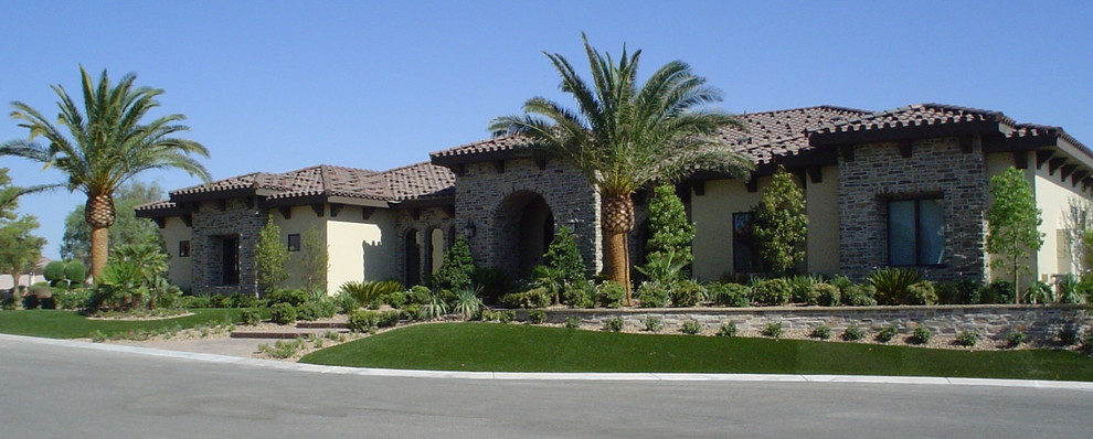 Foto de fachada de casa marrón mediterránea grande de una planta con revestimientos combinados, tejado a cuatro aguas y tejado de teja de barro