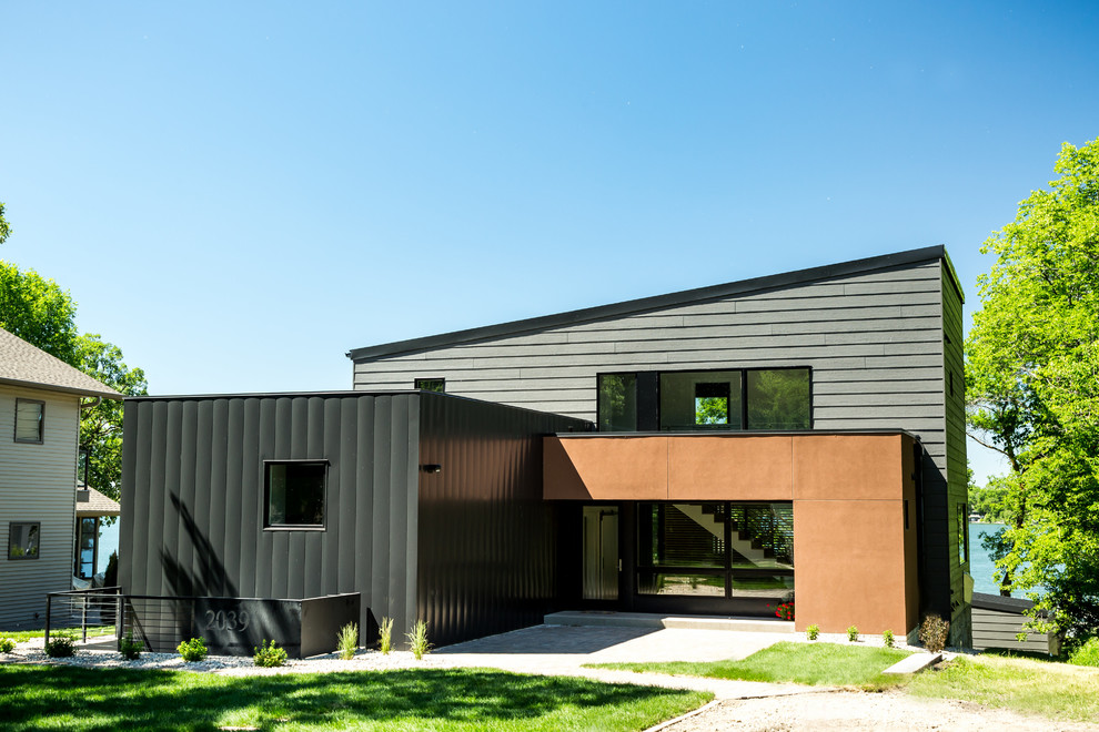 Idées déco pour une façade de maison multicolore contemporaine à un étage avec un revêtement mixte et un toit en appentis.