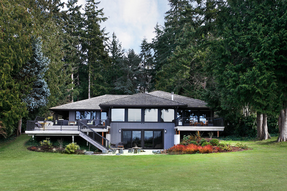 Foto de fachada gris tradicional renovada grande de dos plantas con revestimiento de madera y tejado a cuatro aguas