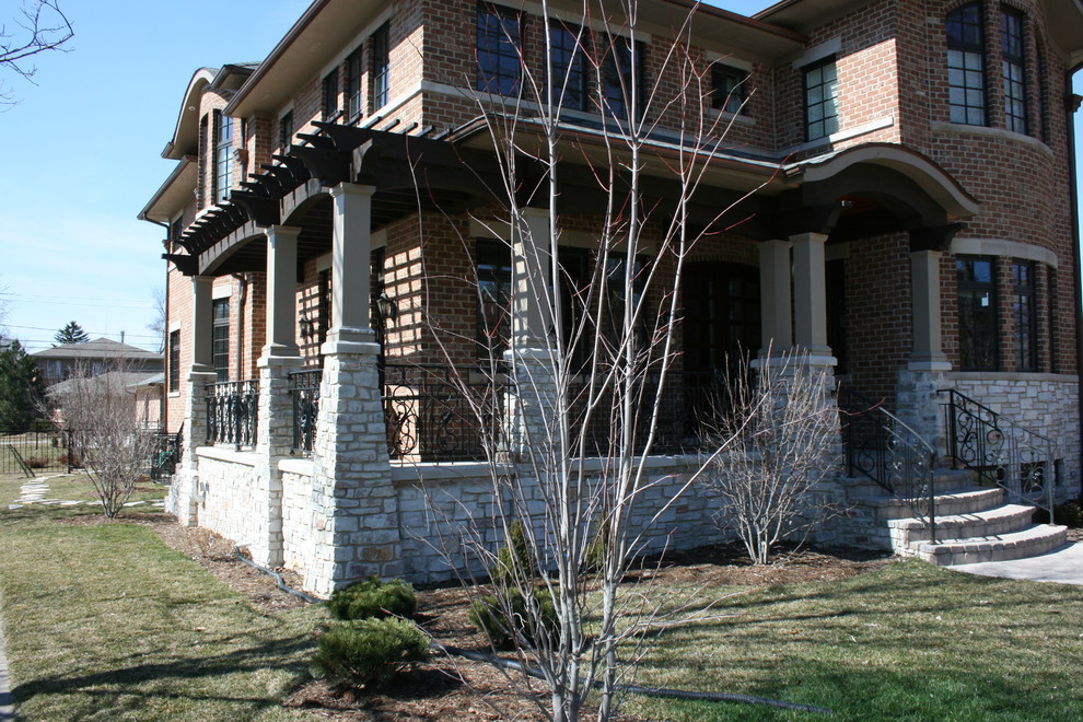 Exempel på ett stort amerikanskt grått hus, med två våningar och tegel