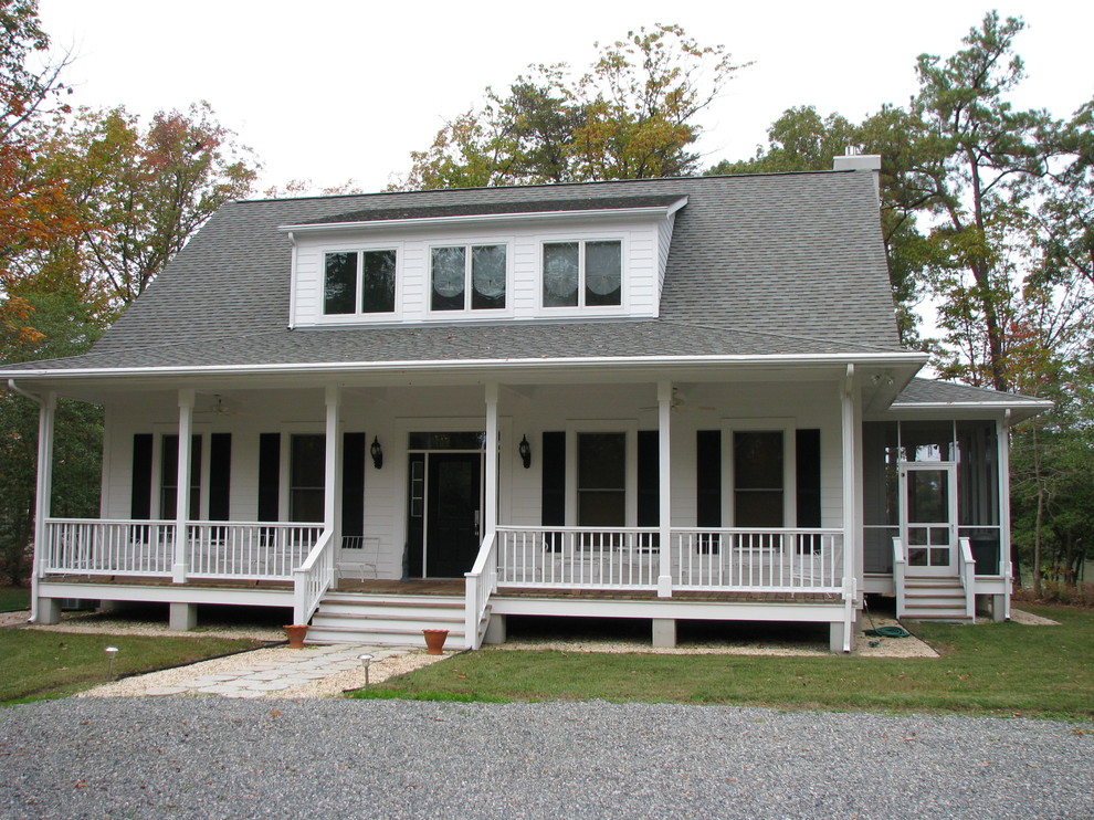Réalisation d'une façade de maison blanche tradition en bois de taille moyenne et à un étage avec un toit à deux pans et un toit en shingle.