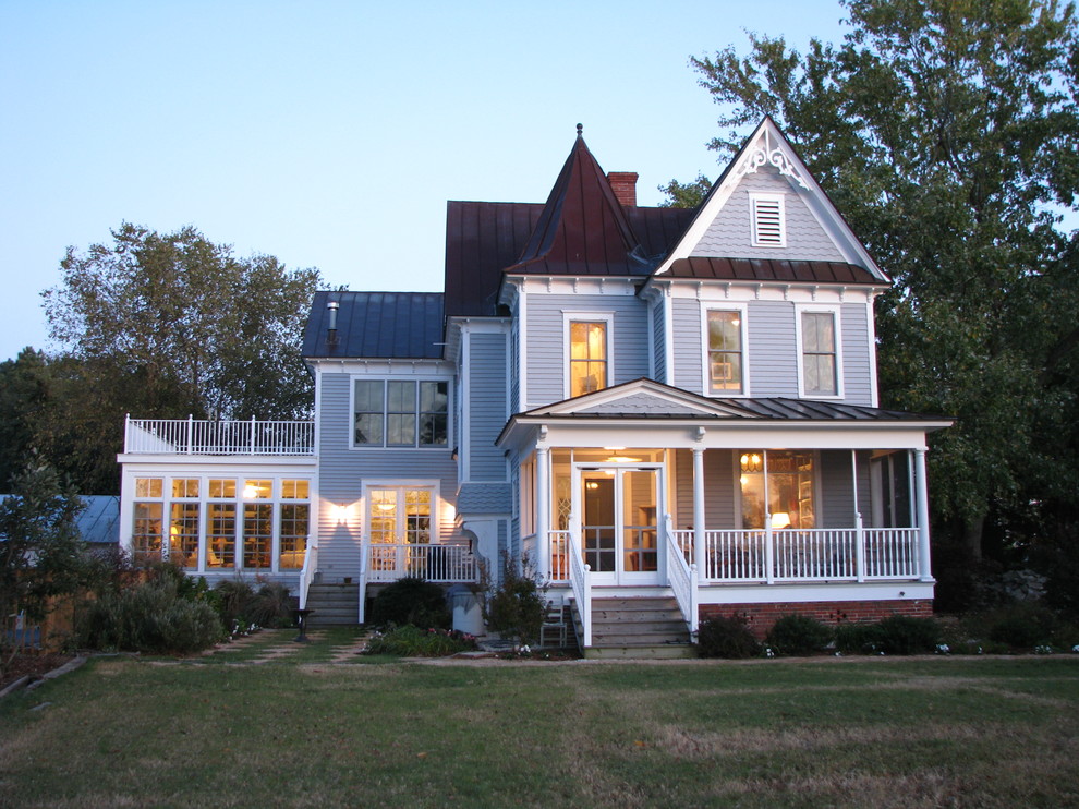 Пример оригинального дизайна: большой, двухэтажный, деревянный, серый частный загородный дом в викторианском стиле с двускатной крышей