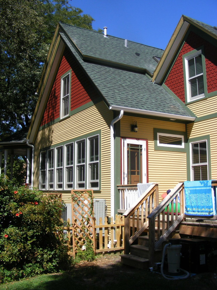 Diseño de fachada de casa amarilla y azul clásica grande de dos plantas con revestimiento de madera, tejado a dos aguas, tejado de teja de madera y tablilla
