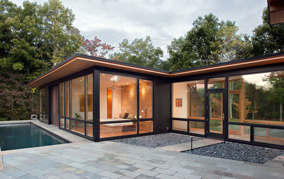 Стильный дизайн: черный частный загородный дом в стиле модернизм с облицовкой из металла и односкатной крышей - последний тренд