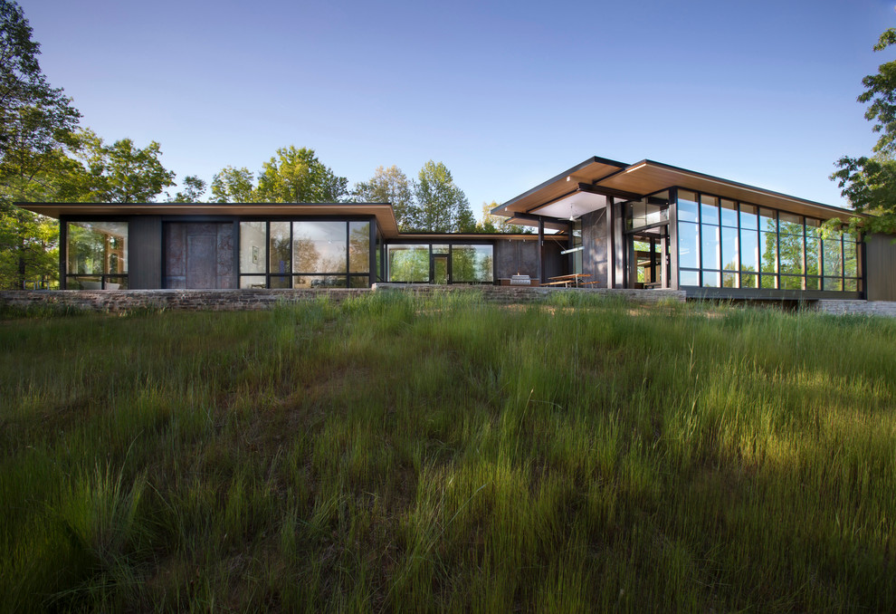 Inspiration pour une façade de maison noire minimaliste en verre de plain-pied avec un toit en appentis.