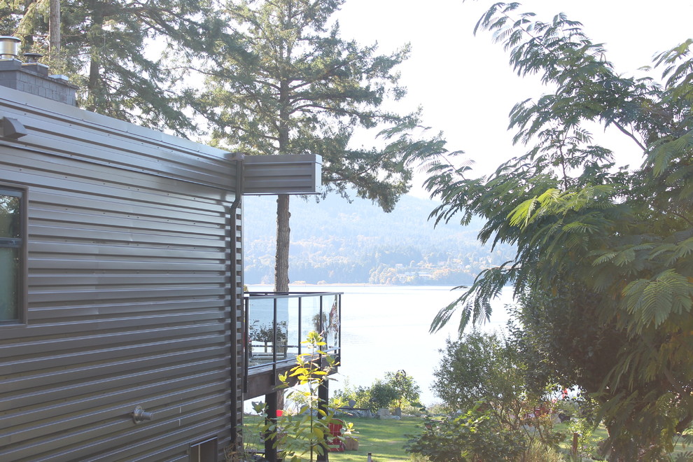 Example of a mid-sized minimalist gray two-story metal exterior home design in Vancouver with a metal roof