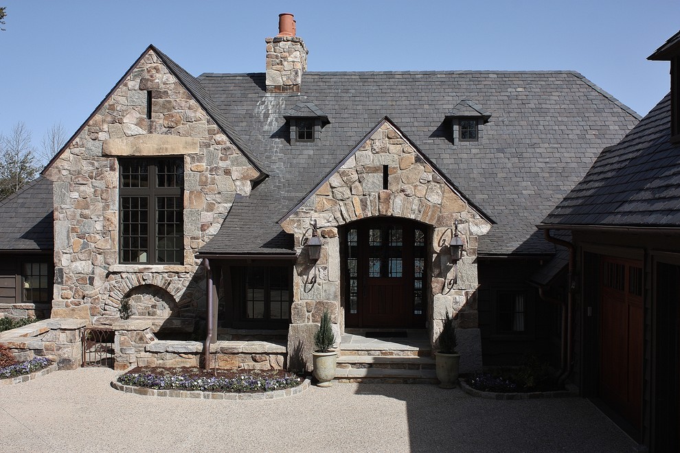 Example of a mid-sized transitional multicolored two-story stone gable roof design in Other