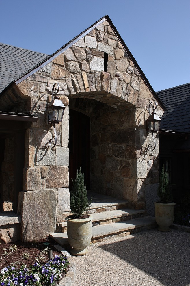 他の地域にある高級な中くらいなラスティックスタイルのおしゃれな家の外観 (石材サイディング、マルチカラーの外壁) の写真