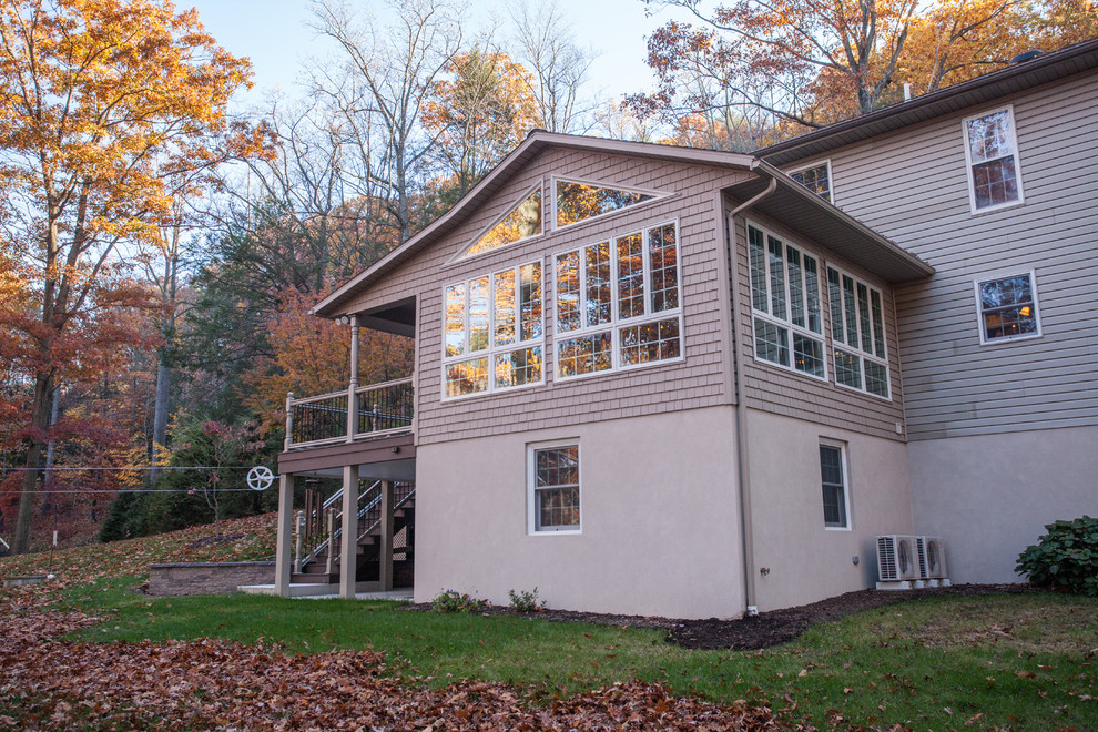 Пример оригинального дизайна: двухэтажный, коричневый дом среднего размера в классическом стиле с облицовкой из винила и двускатной крышей