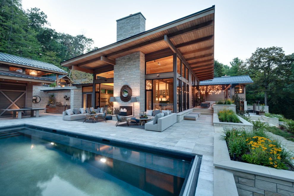 Ejemplo de fachada de casa marrón minimalista extra grande con revestimientos combinados y tejado plano