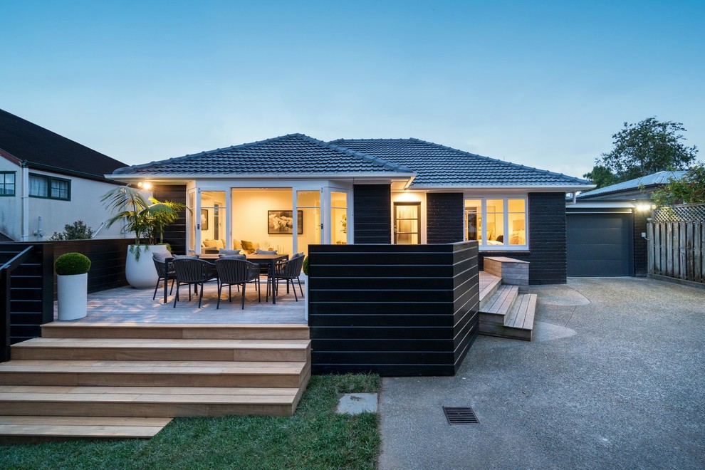 Стильный дизайн: маленький, одноэтажный, кирпичный, черный частный загородный дом в стиле модернизм с вальмовой крышей и черепичной крышей для на участке и в саду - последний тренд