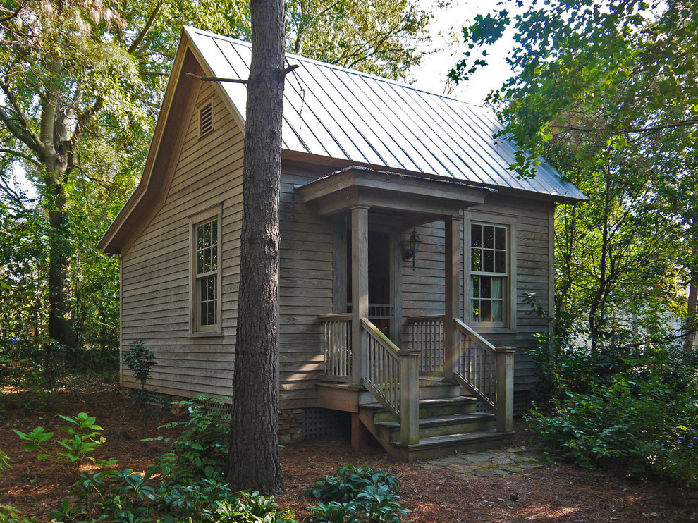Photo of a small rustic house exterior in Atlanta with wood cladding and a pitched roof.