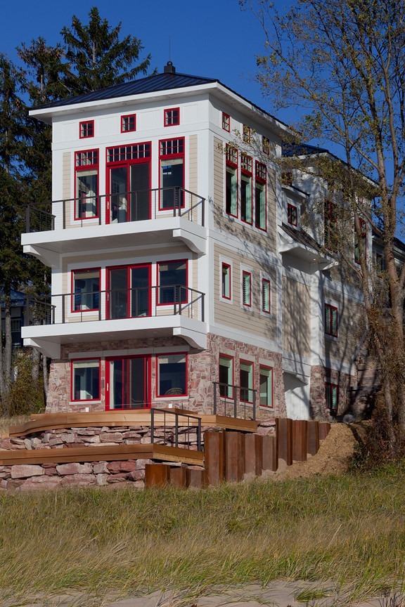 Ispirazione per la facciata di una casa grande beige stile marinaro a tre piani con rivestimento con lastre in cemento