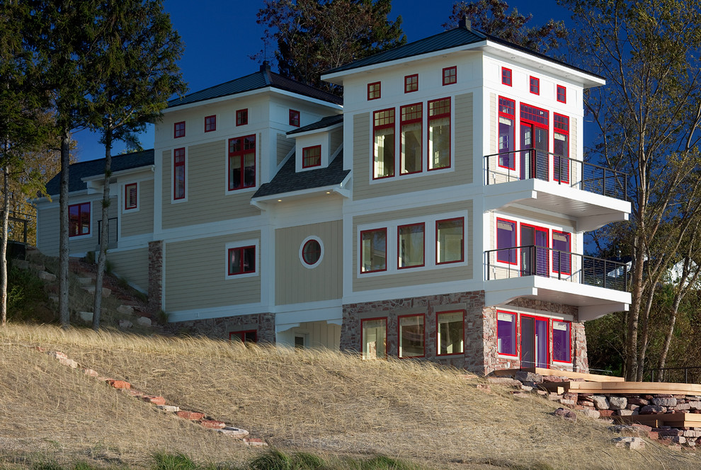 Idee per la facciata di una casa grande beige classica a tre piani con rivestimento con lastre in cemento e tetto a padiglione