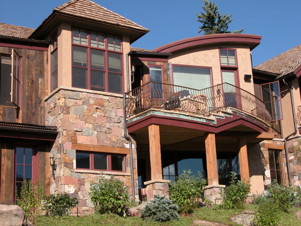 Immagine della villa grande beige rustica a piani sfalsati con rivestimenti misti, tetto a capanna e copertura a scandole