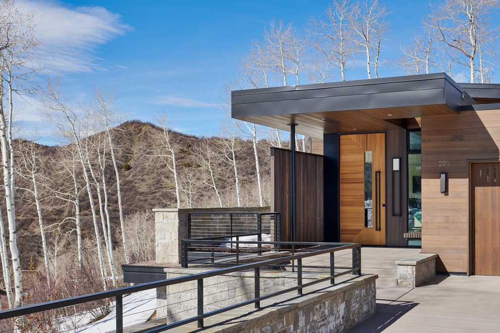Réalisation d'une grande façade de maison marron minimaliste en bois à un étage avec un toit plat et un toit en métal.