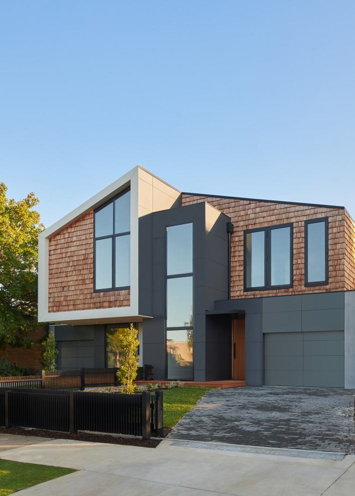 Cette photo montre une façade de maison de ville grise tendance en bois de taille moyenne et à un étage avec un toit à deux pans et un toit en shingle.