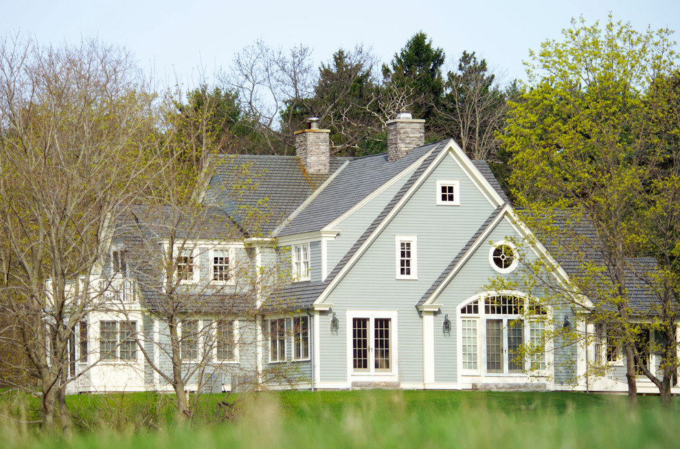 На фото: большой, двухэтажный, деревянный, зеленый дом в классическом стиле с