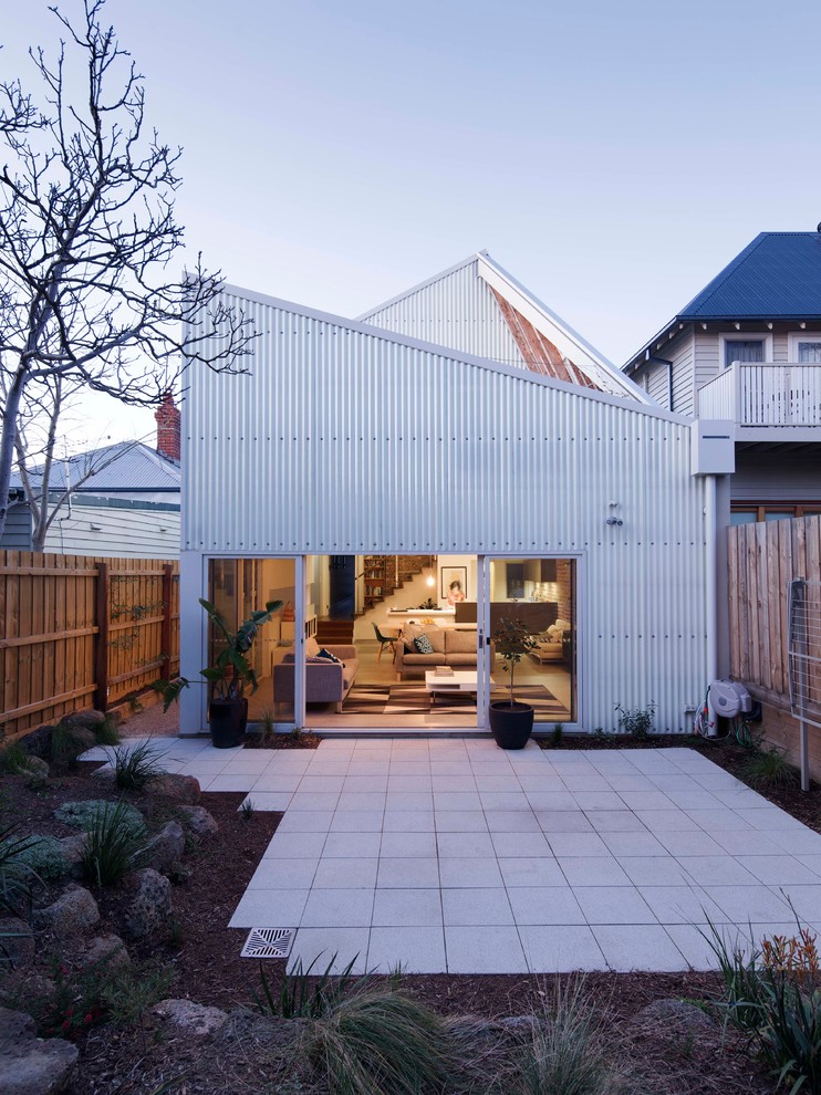 Идея дизайна: двухэтажный частный загородный дом в стиле лофт с облицовкой из металла, односкатной крышей и металлической крышей
