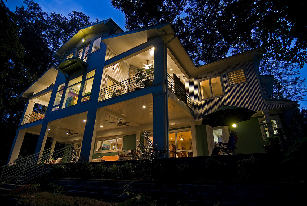 Пример оригинального дизайна: огромный, трехэтажный, синий частный загородный дом в стиле фьюжн с облицовкой из металла, двускатной крышей и металлической крышей