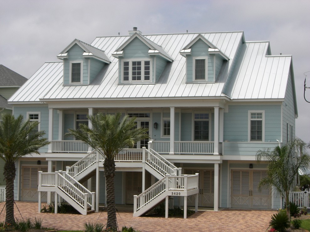 Esempio della facciata di una casa grande blu stile marinaro a tre piani con rivestimento con lastre in cemento e tetto a capanna